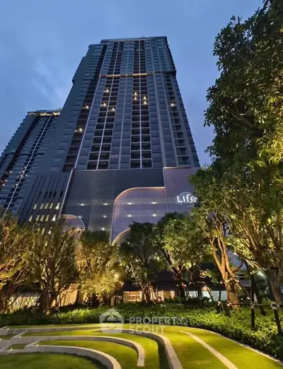 Stunning high-rise building with lush landscaped garden and modern architecture.