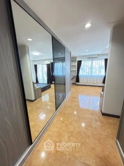 Spacious modern living room with large windows and glossy tiled floors