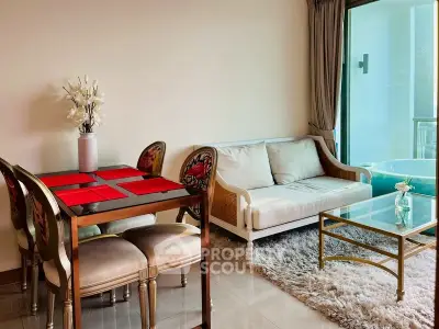 Elegant living room with plush rug, glass coffee table, and dining area in modern apartment.