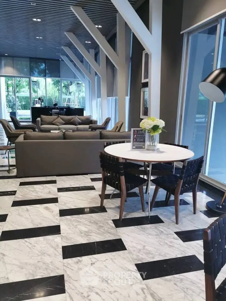 Luxurious modern living room with stylish furniture and large windows offering a serene garden view.