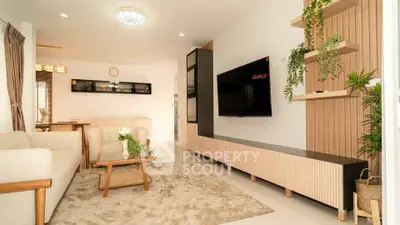 Modern living room with stylish decor and wall-mounted TV in a cozy apartment.
