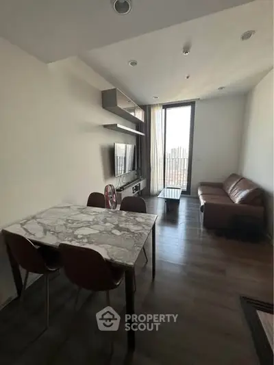 Modern living room with marble dining table and cozy seating area, featuring sleek design and natural light.