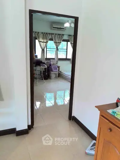 Spacious bedroom with natural light and tiled flooring, featuring a cozy bed and study area.