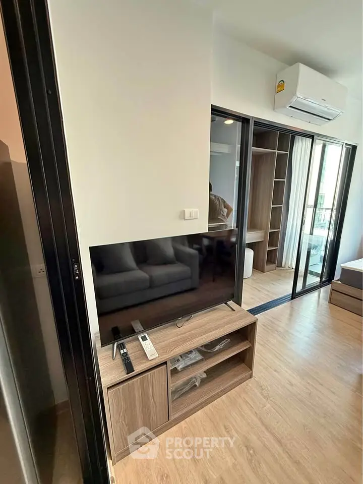 Modern living room with sleek TV stand and air conditioning in stylish apartment.