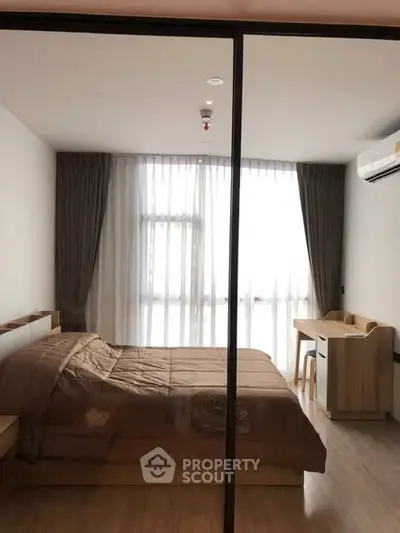 Modern bedroom with large window and stylish wooden furniture