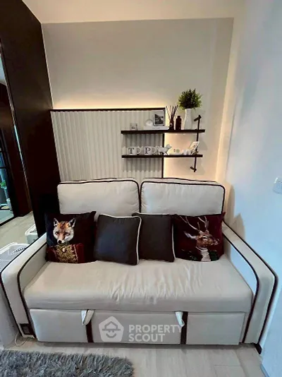 Cozy living room with stylish sofa and decorative pillows, perfect for relaxation.