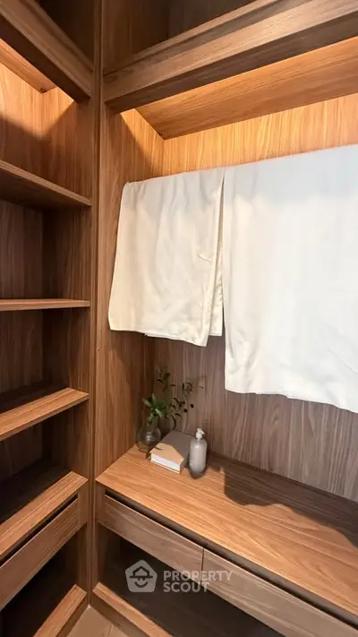 Luxurious walk-in closet with wooden shelves and elegant decor