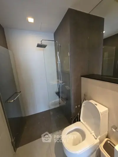Modern bathroom with glass shower and sleek design in luxury apartment.