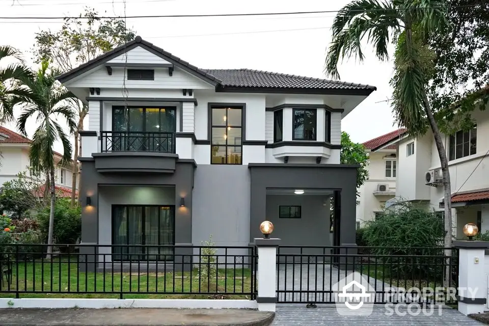 Modern two-story house with sleek design, large windows, and lush garden, perfect for family living.