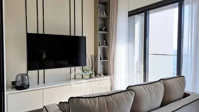 Modern living room with sleek TV setup and large window balcony view.