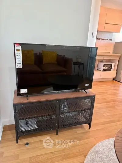 Modern living room with sleek TV stand and cozy kitchen view