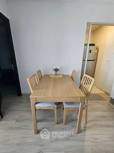 Modern dining area with wooden table and chairs in a cozy apartment setting.