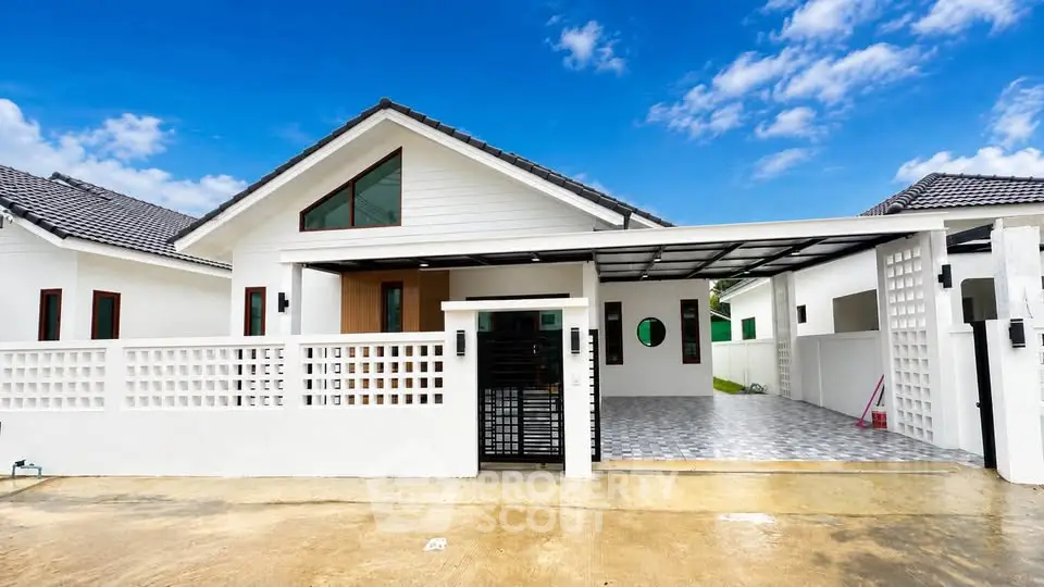 Charming modern house with spacious driveway and stylish facade under a clear blue sky.