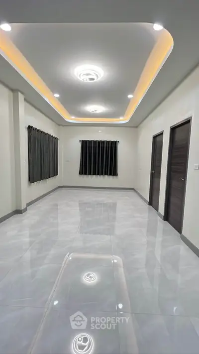 Spacious modern room with sleek lighting and glossy tiled floor