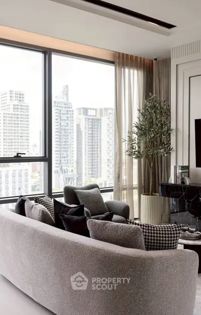 Modern living room with city view, stylish furniture, and large windows in a high-rise apartment.