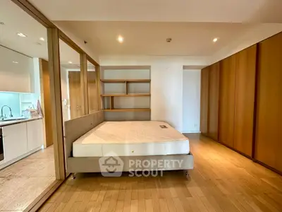 Spacious bedroom with modern design and built-in storage in a luxury apartment.