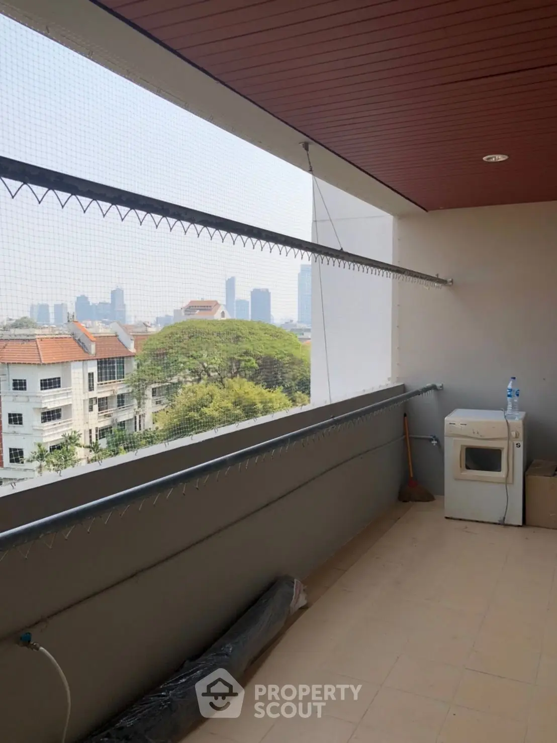 Spacious balcony with city view and laundry area in modern apartment