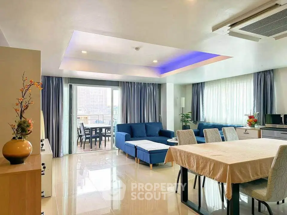 Spacious modern living room with elegant dining area and large windows offering natural light.
