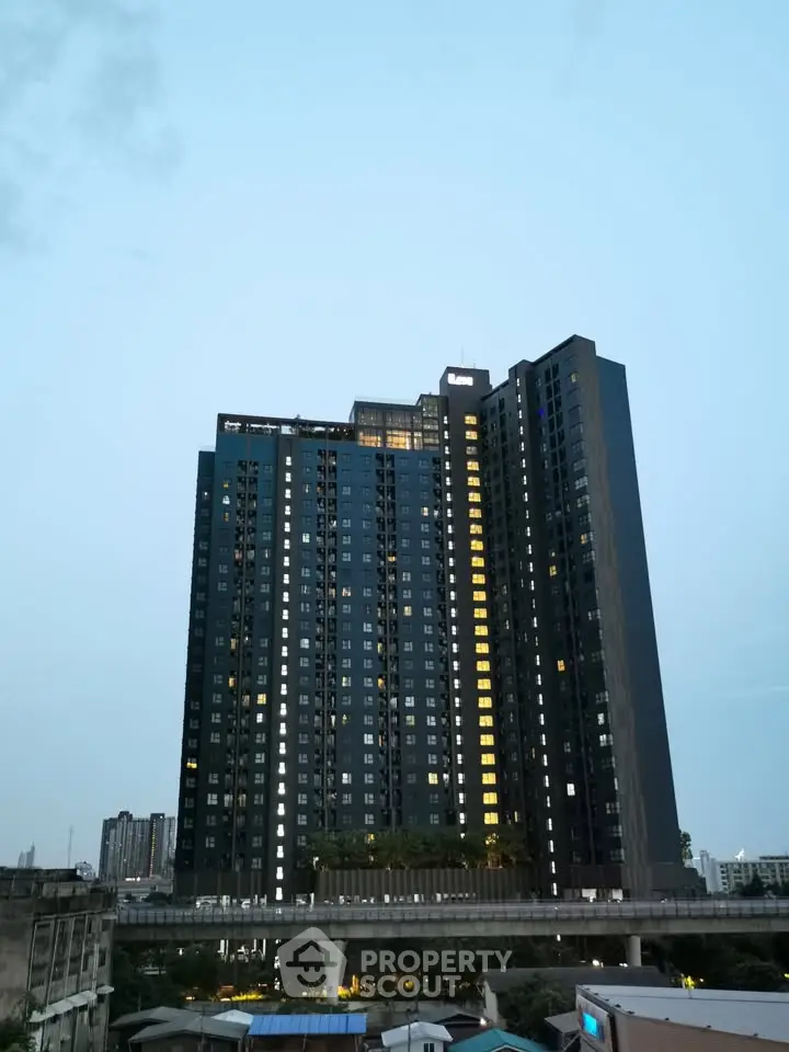 Stunning high-rise building with illuminated windows against a twilight sky, showcasing urban living at its finest.