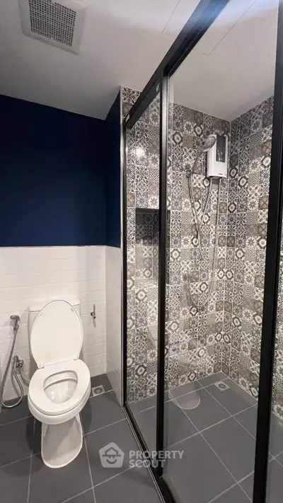 Modern bathroom with stylish patterned tiles and glass shower enclosure