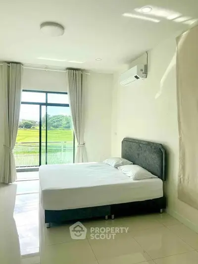 Bright bedroom with large window and scenic view, featuring modern bed and air conditioning.