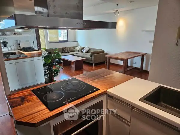 Modern open-layout kitchen with sleek appliances and cozy living room area.