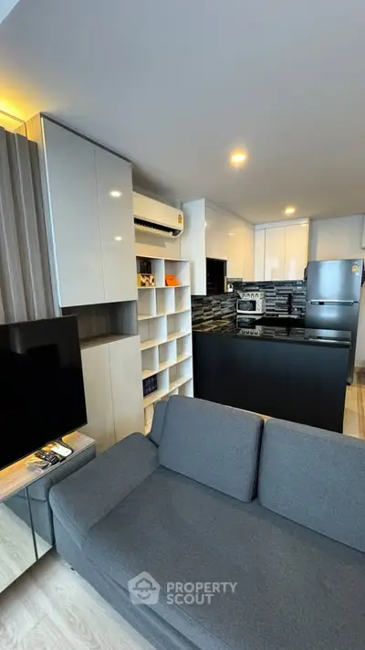 Modern open-layout living room with sleek kitchen and stylish decor