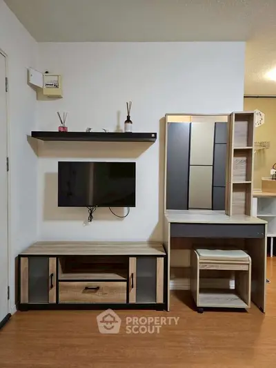 Modern living room with sleek TV setup and stylish wooden furniture, perfect for cozy urban living.