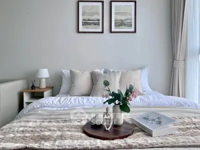 Elegant bedroom with cozy decor and natural light, featuring plush bedding and stylish artwork.