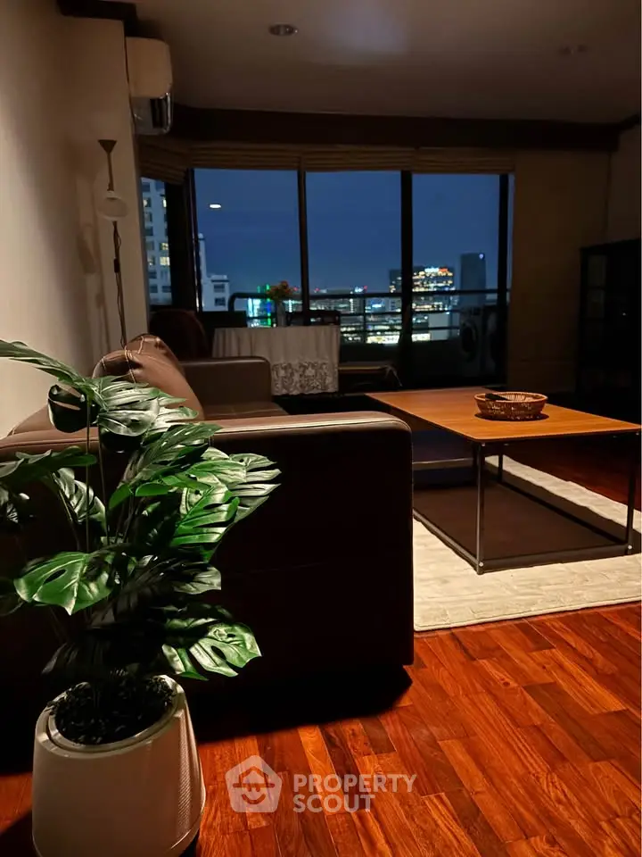Chic living room with city view, modern furniture, and warm lighting for cozy evenings.