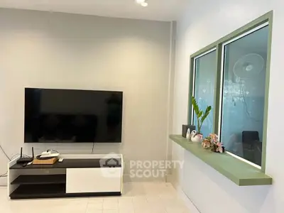 Modern living room with sleek TV setup and decorative window ledge.