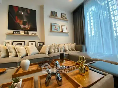 Modern living room with stylish decor and large windows offering city views.