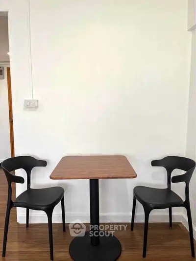 Minimalist dining area with modern black chairs and wooden table