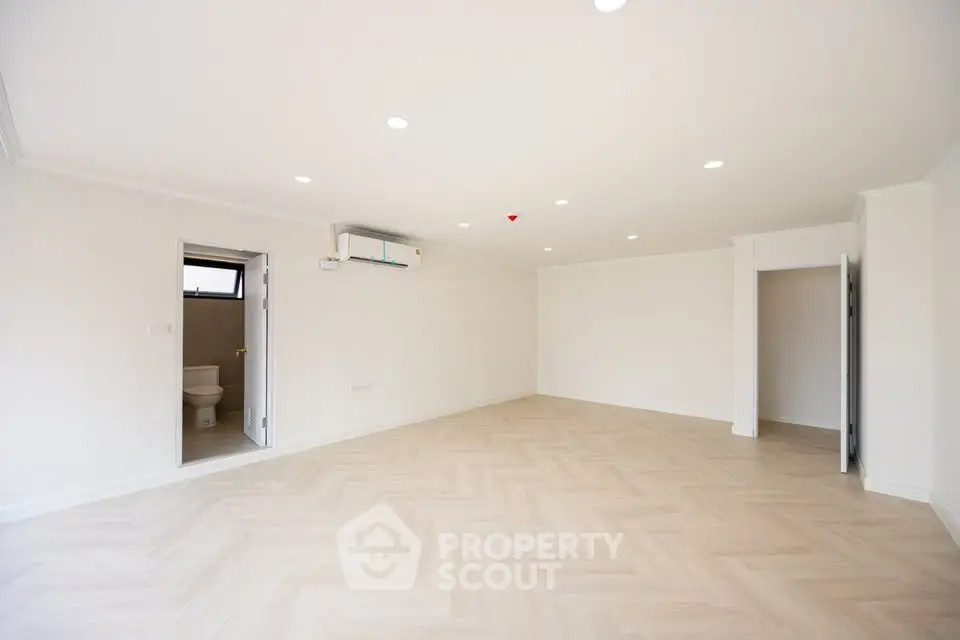 Spacious unfurnished living room with modern lighting and light wood flooring