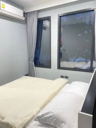 Cozy bedroom with large windows and modern air conditioning unit