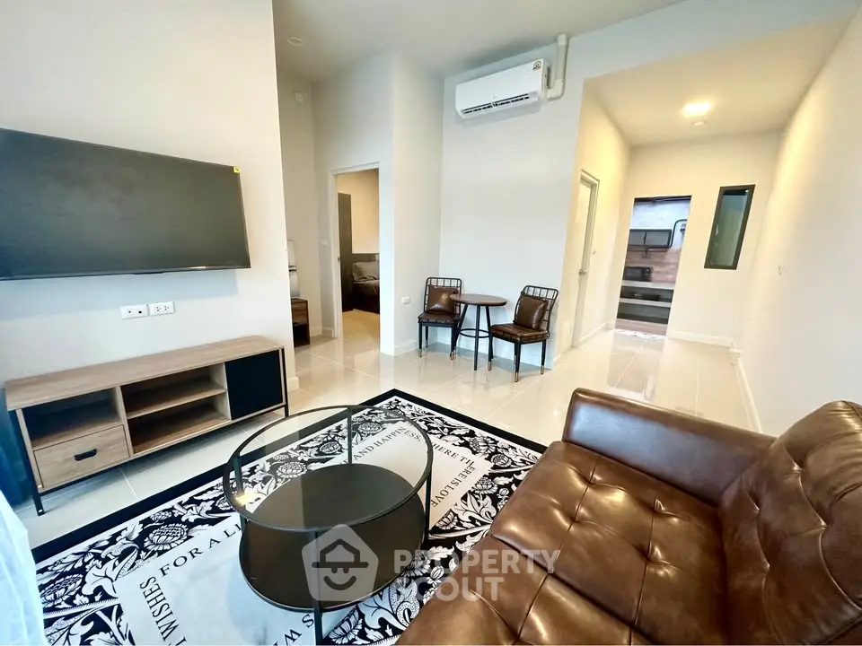 Modern living room with leather sofa and wall-mounted TV in stylish apartment