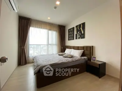 Cozy bedroom with large window and stylish decor in modern apartment.
