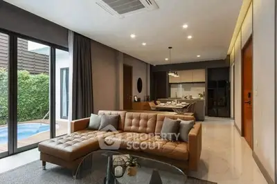 Luxurious living room with modern decor and pool view, featuring a spacious open layout and elegant furnishings.