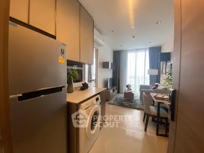 Modern apartment interior with open kitchen and cozy living room, featuring stylish decor and natural light.