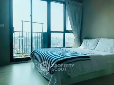 Bright bedroom with large window and city view, featuring a cozy bed and modern decor.