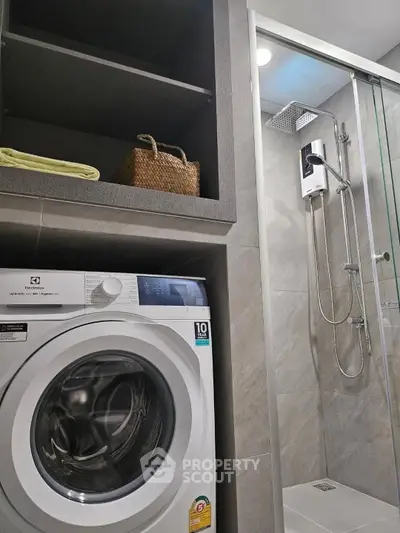 Modern bathroom with washing machine and sleek shower area