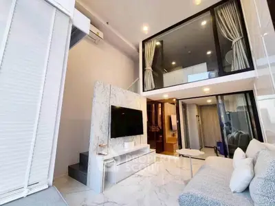 Luxurious modern living room with high ceilings and mezzanine, featuring elegant marble accents and stylish furnishings.