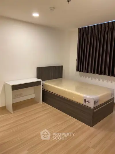 Modern minimalist bedroom with single bed and desk, perfect for urban living.