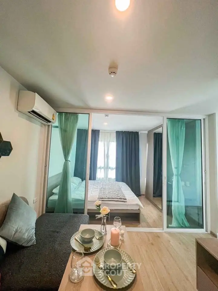 Modern studio apartment with glass partition, cozy living area, and stylish decor.