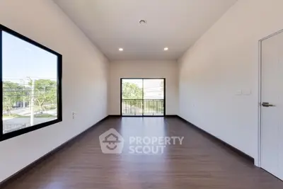 Spacious modern room with large windows and wooden flooring