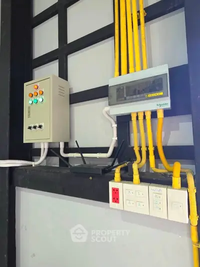 Industrial electrical panel setup with yellow pipes and control switches