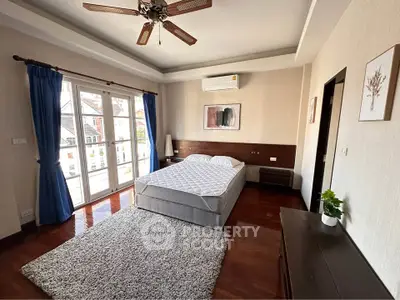 Spacious bedroom with elegant decor and large windows for natural light.