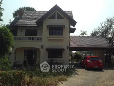 Charming two-story house with tiled roof and attached carport in serene neighborhood.