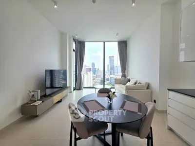 Modern living room with city view, featuring sleek furniture and large windows in a high-rise apartment.