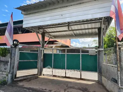 Charming gated entrance with traditional flags and metal fencing, perfect for secure and private living.